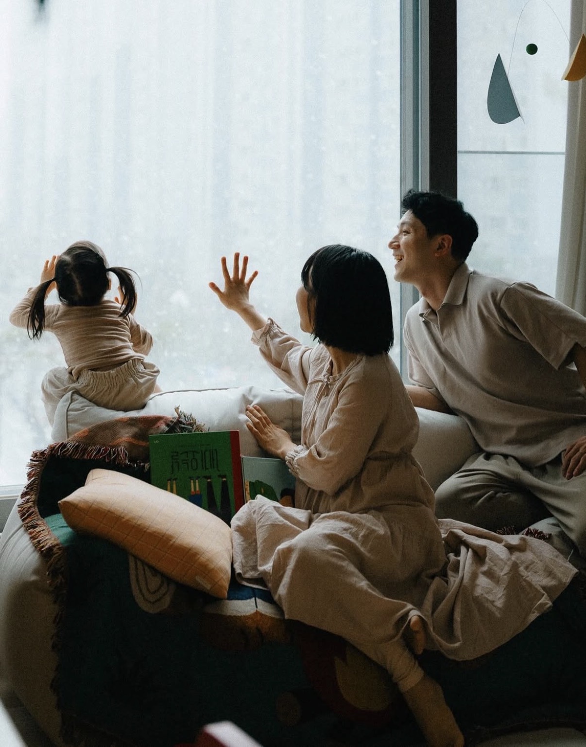비 오는 날 창가의 가족